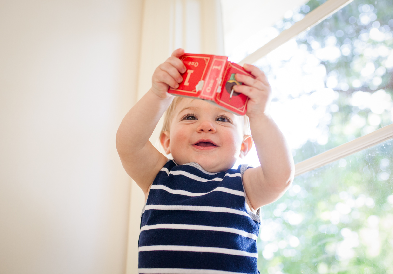 Baby looking at red book | Commercial Lifestyle Photographer