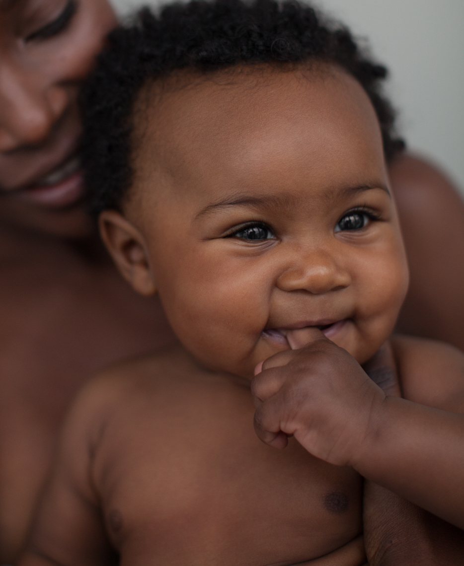 Smiling baby held by mom  | Commercial Lifestyle Photographer