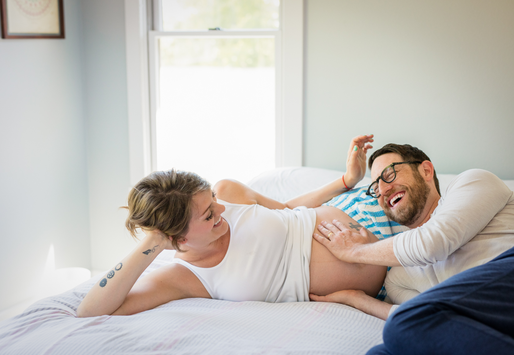 Joyful pregnant couple on bed | Commercial Lifestyle Photographer