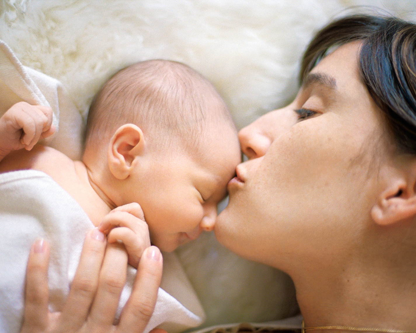 Loving mom kissing newborn | Commercial Kids Photographer