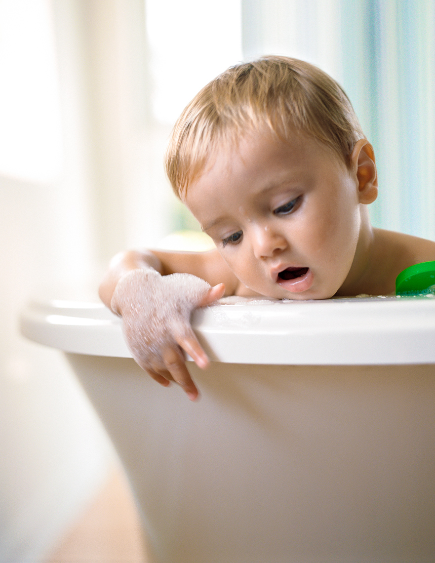 Toddler leaning over bathtub | Kids Lifestyle Photographer