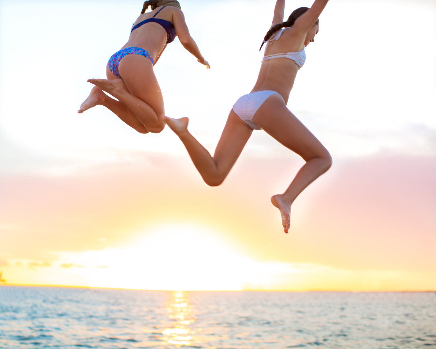 Teens leaping into ocean sunset | Commercial Lifestyle Photographer