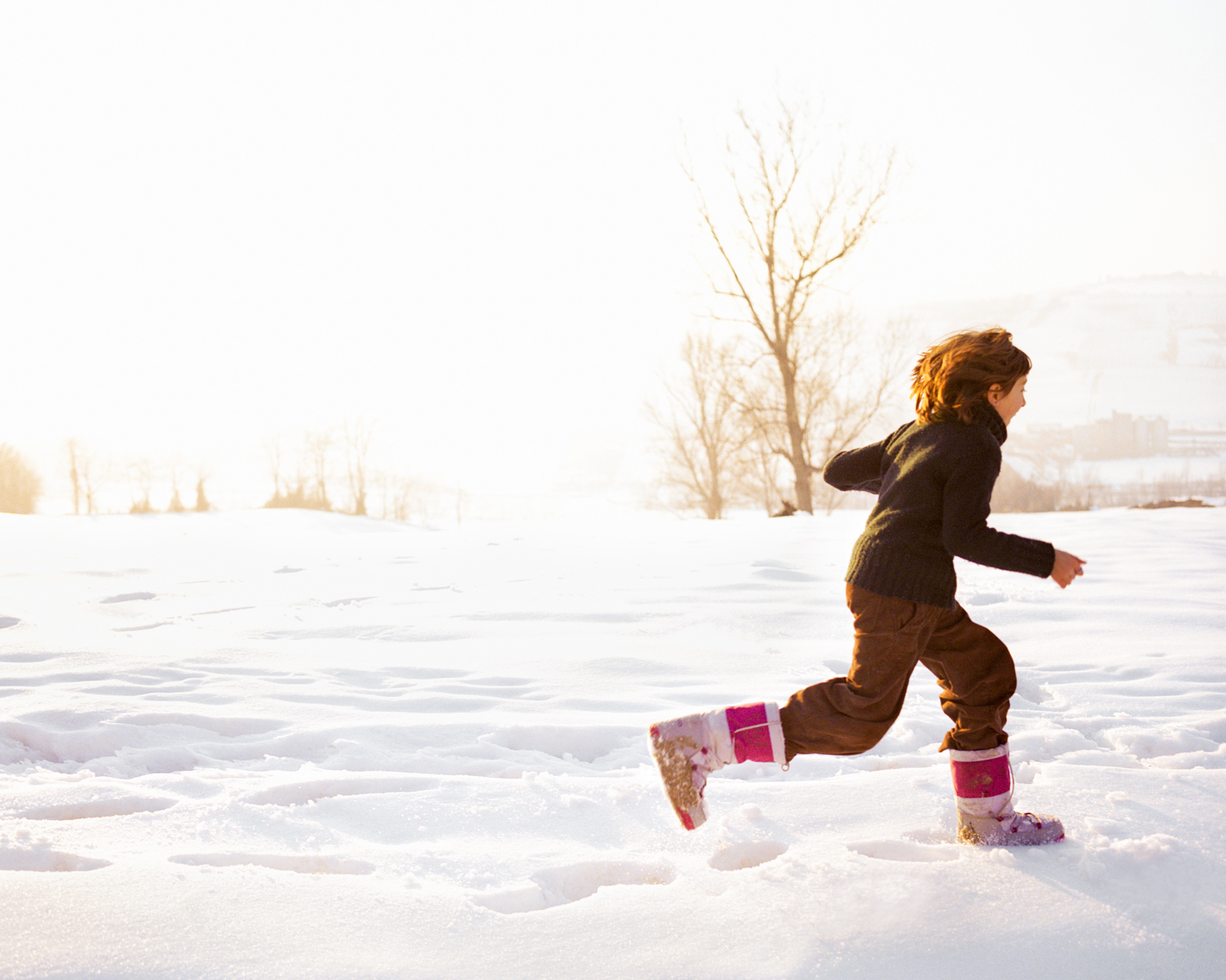 Uplifting girl running in snow | Commercial Lifestyle Photographer